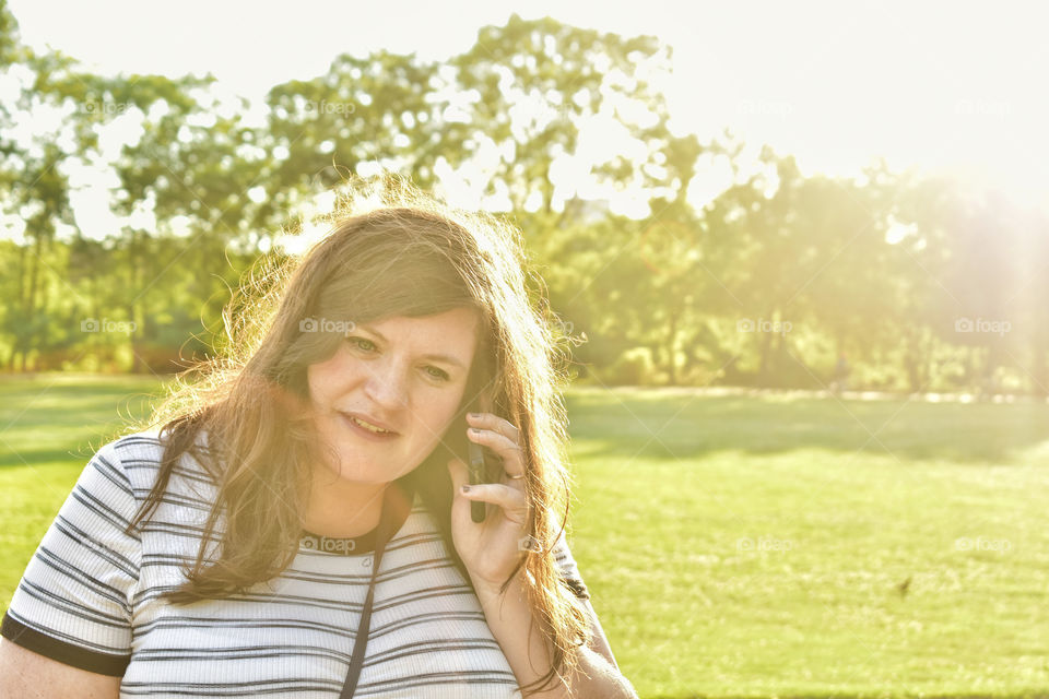Beautiful young woman millenial answering call on mobile phone