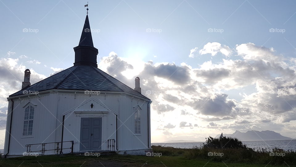 An hexagonal white chapel near the seashore. Andøya. Norway.