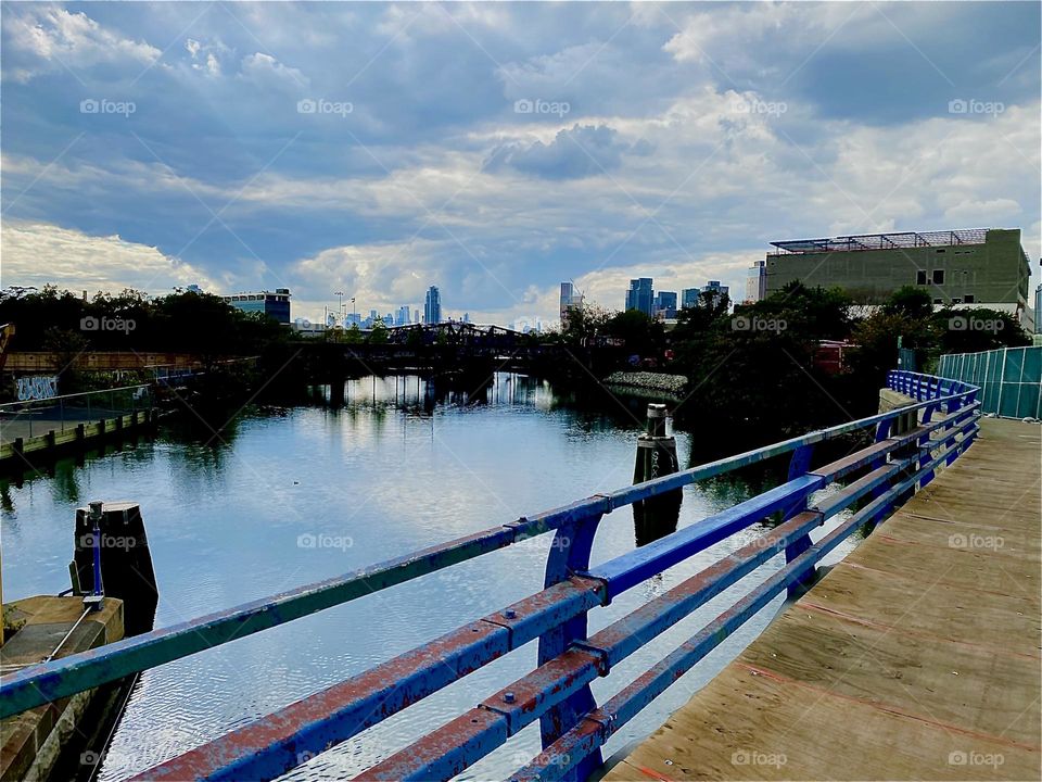This is the „Borden Avenue Bridge“ over „Dutch Kills“, an ocean inlet of the „East River“ in LIC, Queens. The water is perfectly still today and therefore makes a great mirror of the heavens above. 2023. Hypnotic Prodiuctions