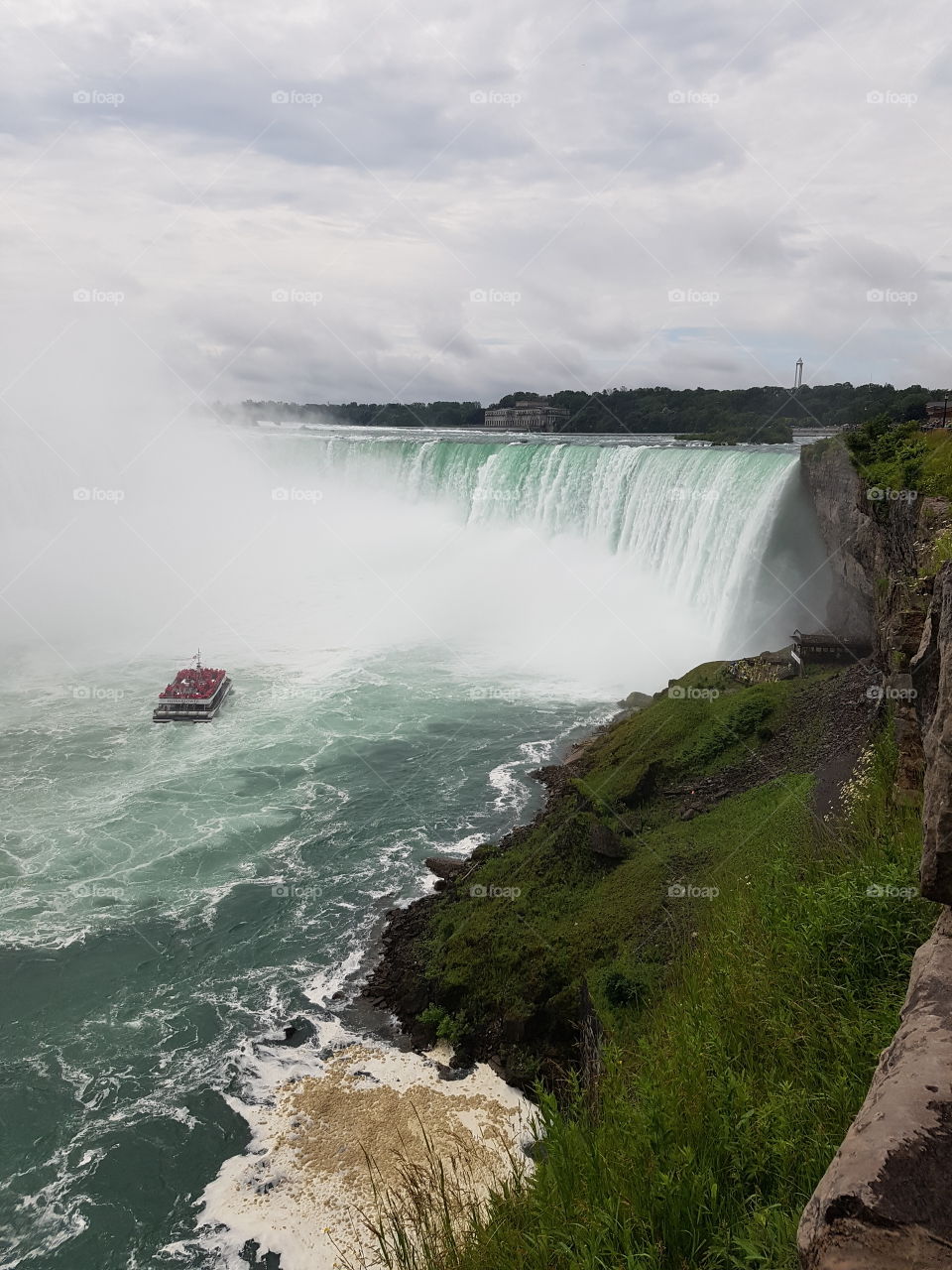 A shot of the maid of the mist tour boat in Niagara Falls, Ontario headed to get a close up of this massive waterfall.