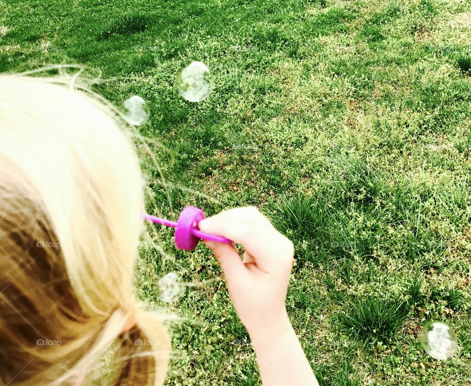 Blonde girl blowing bubbles