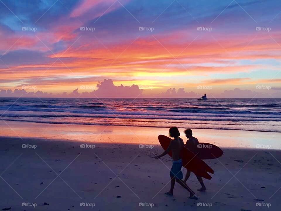 Surfers. Daybreak. Vibrant colors. 