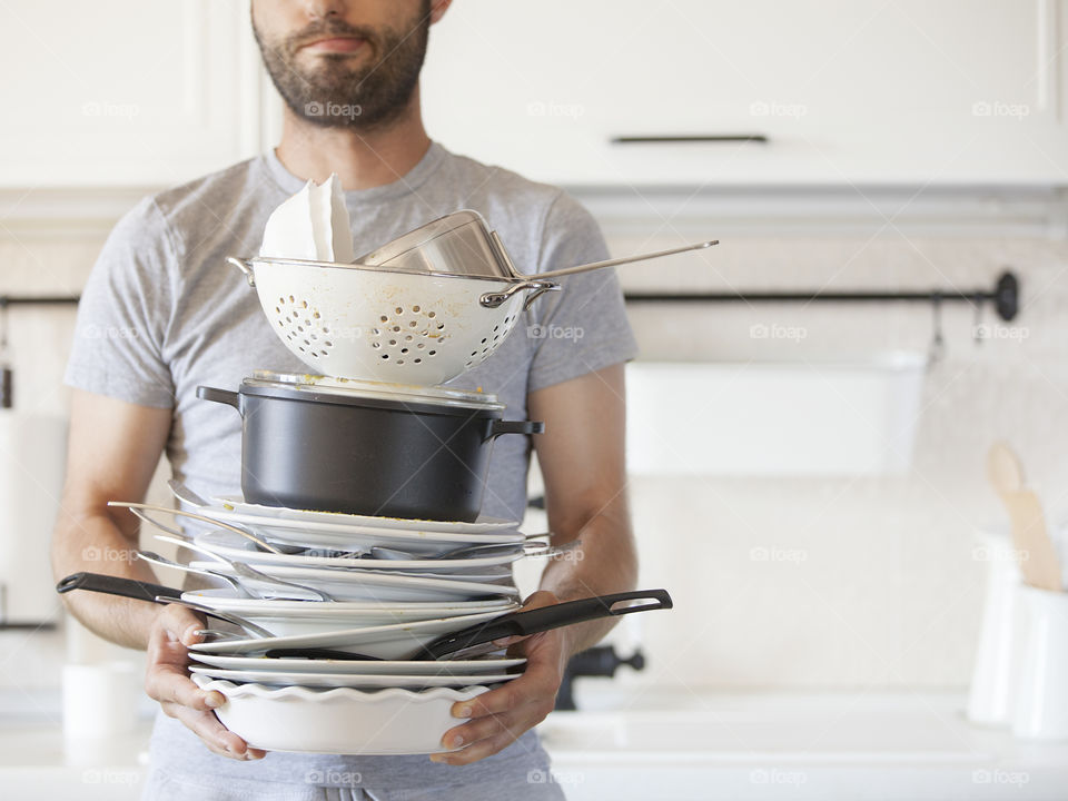 Man holding a lot of dirty dishes
