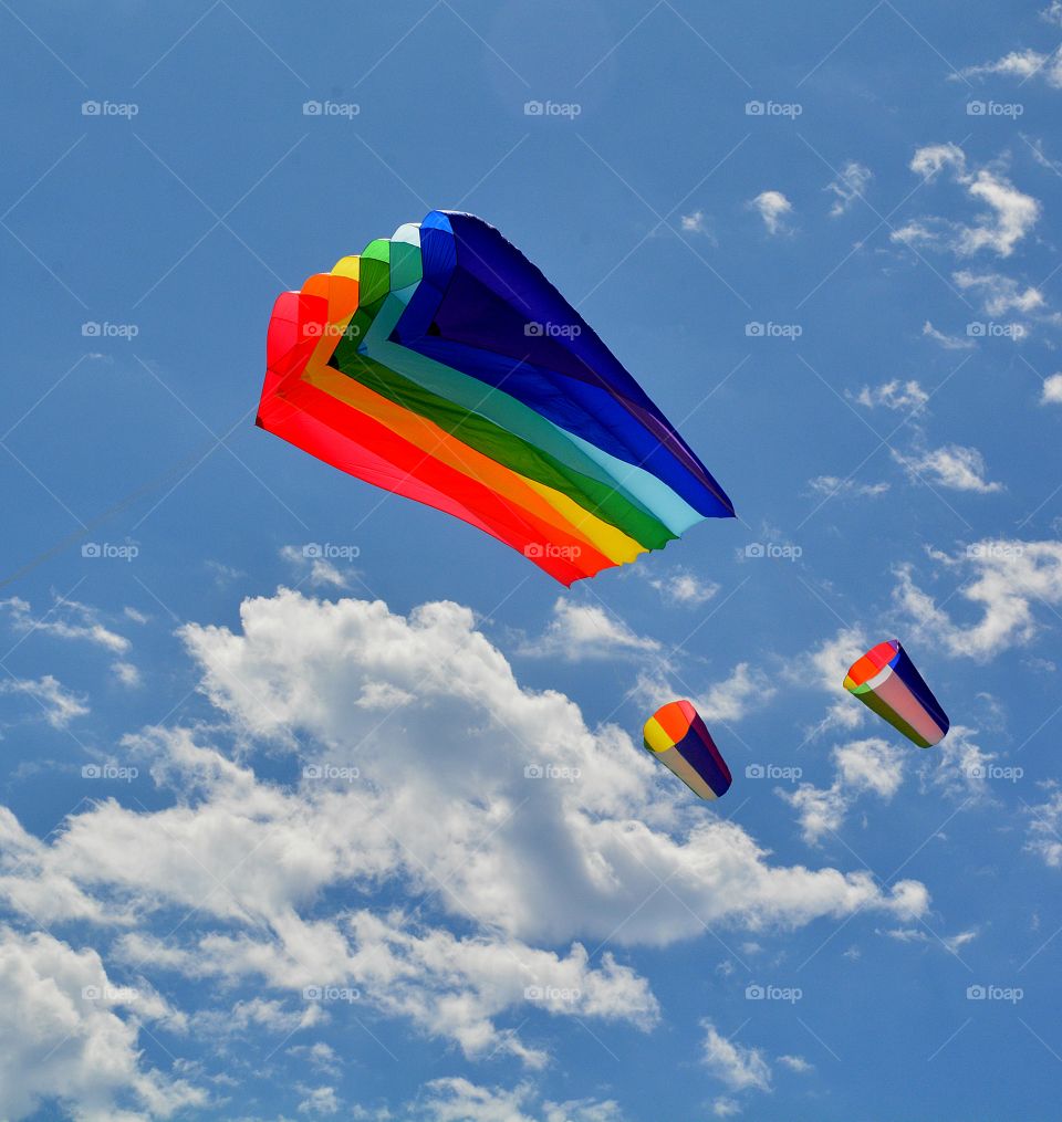 Color vs Black and White - A photo of a colorful high flying kite in a blue sky with puffy clouds