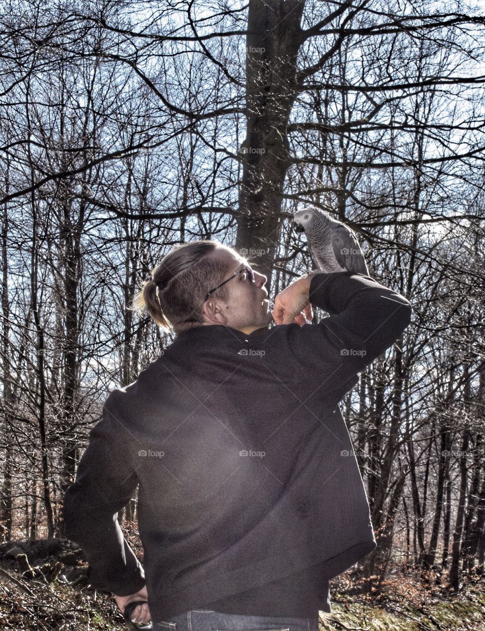 Rear view of a man with grey parrot