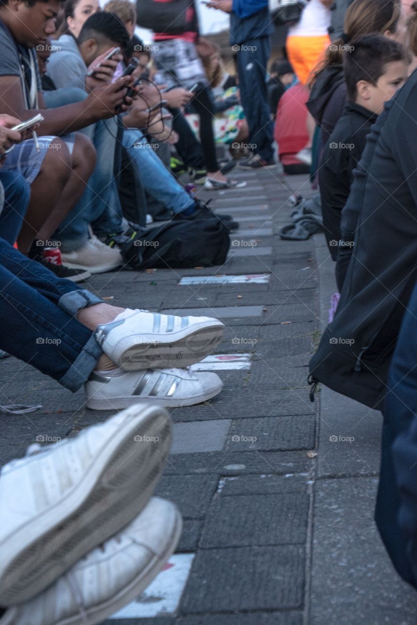 People sitting on the street being online on their phone