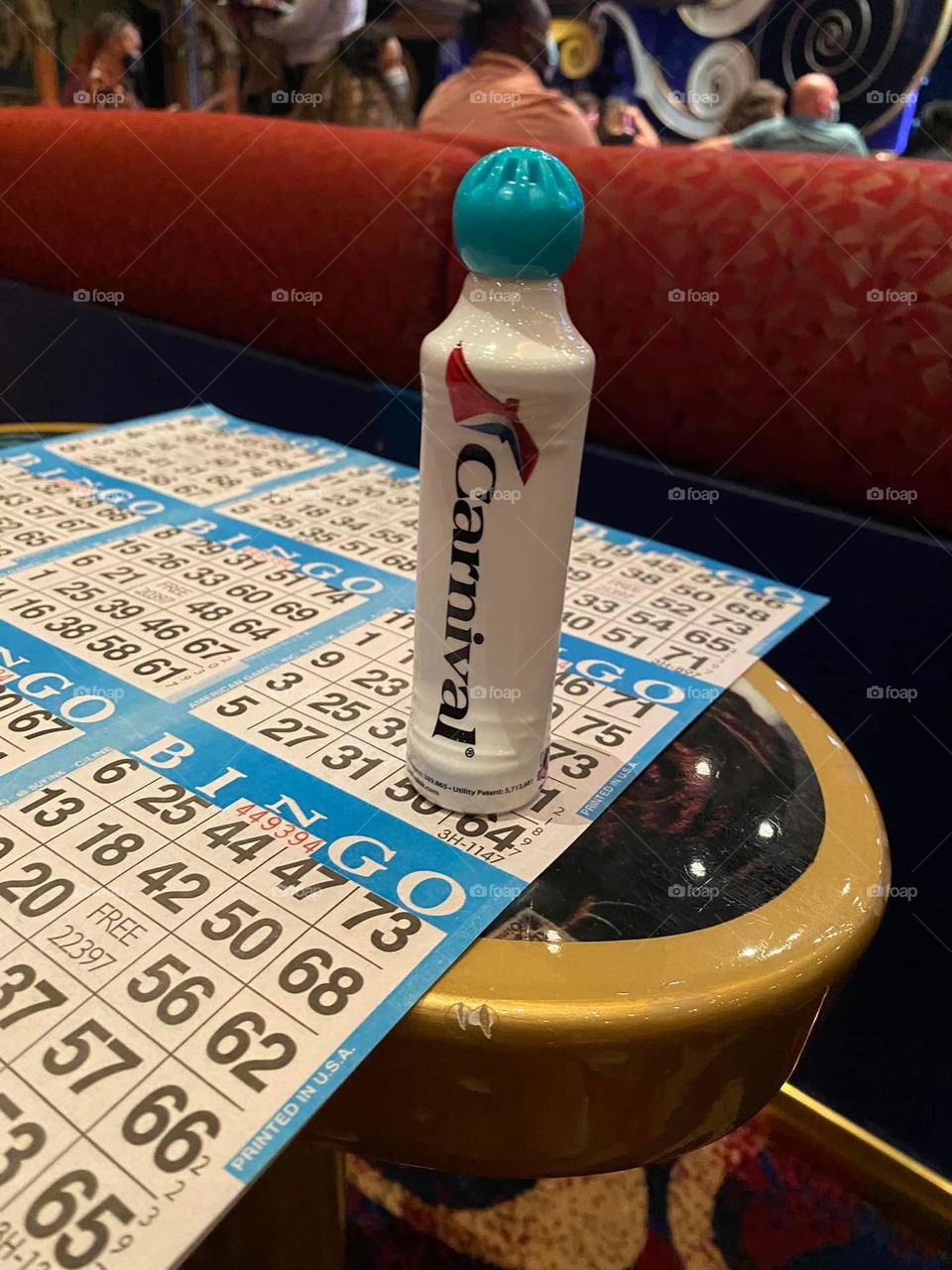 A bingo card and Carnival bingo dobber are atop a table ready to play. 