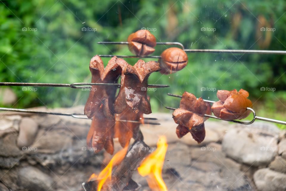 cooking the sausages and meat over the fire