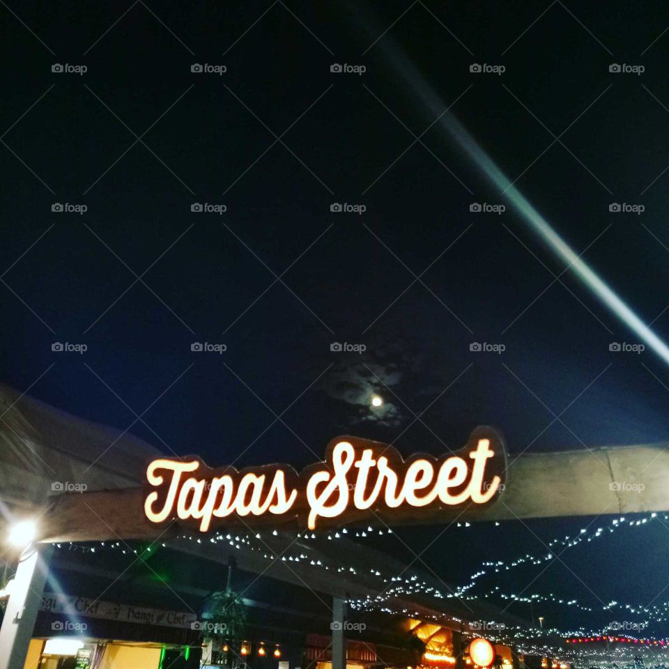 neon tapas street food market sign,  with full moon behind