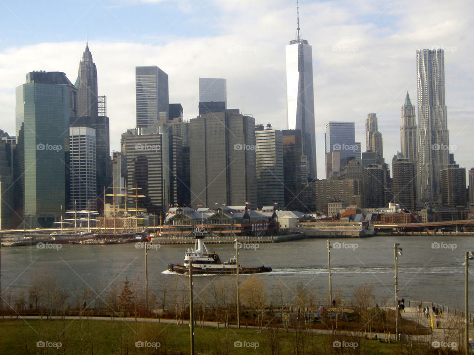 Barge floating down East River against NYC Manhattan background
