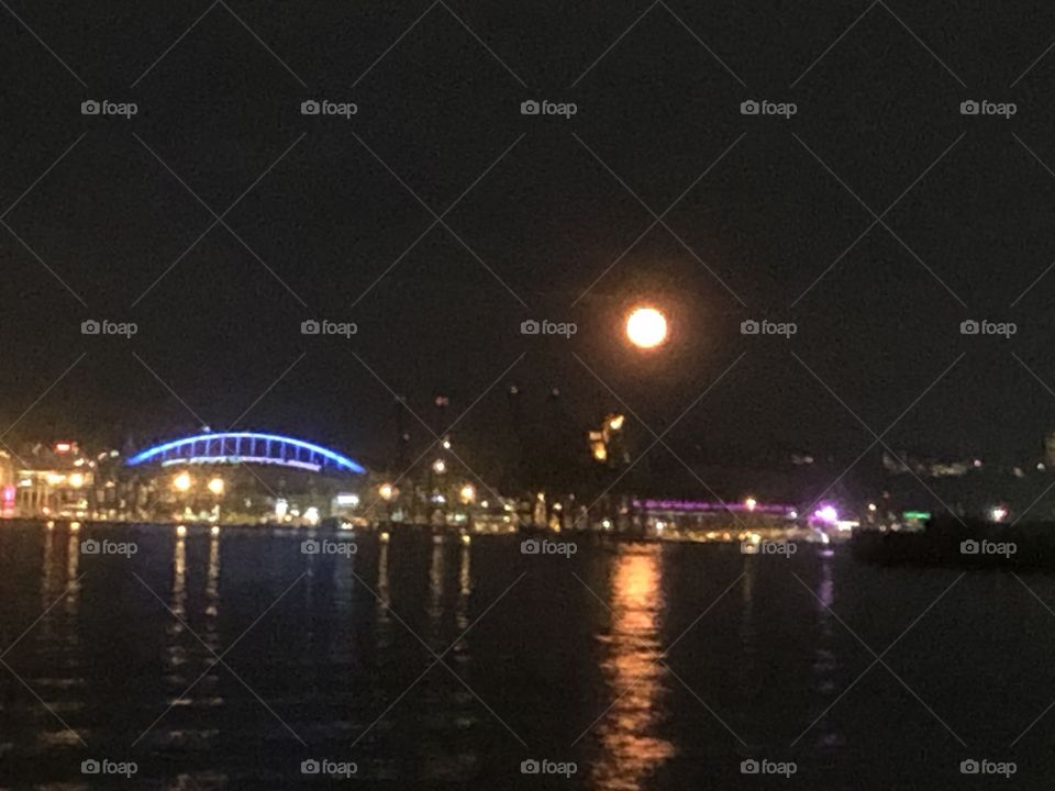 A bright full moon rising up in the sky over the Pacific Ocean 