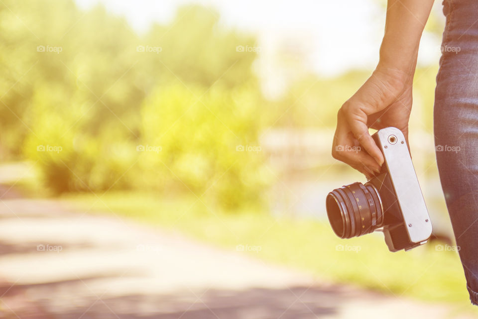 Woman hand holding retro camera. Young girl-photographer with film camera