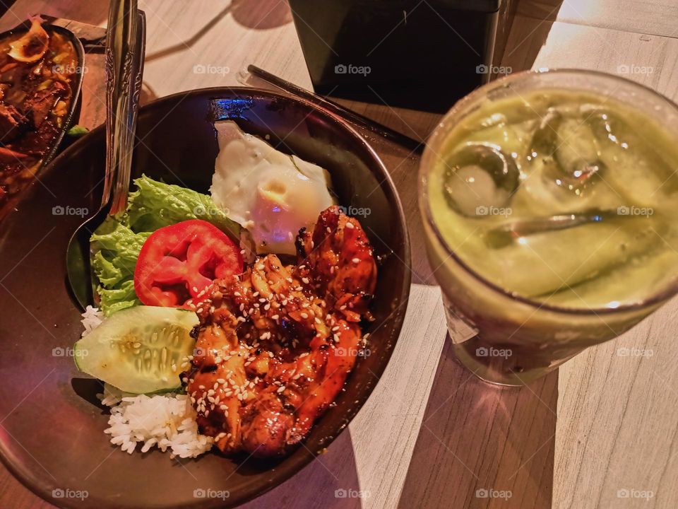 Grilled chicken with rice, salad, tomato, tempeh and sambal (Indonesia chilli sauce) on table