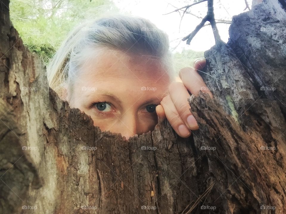 Woman looking through a tree