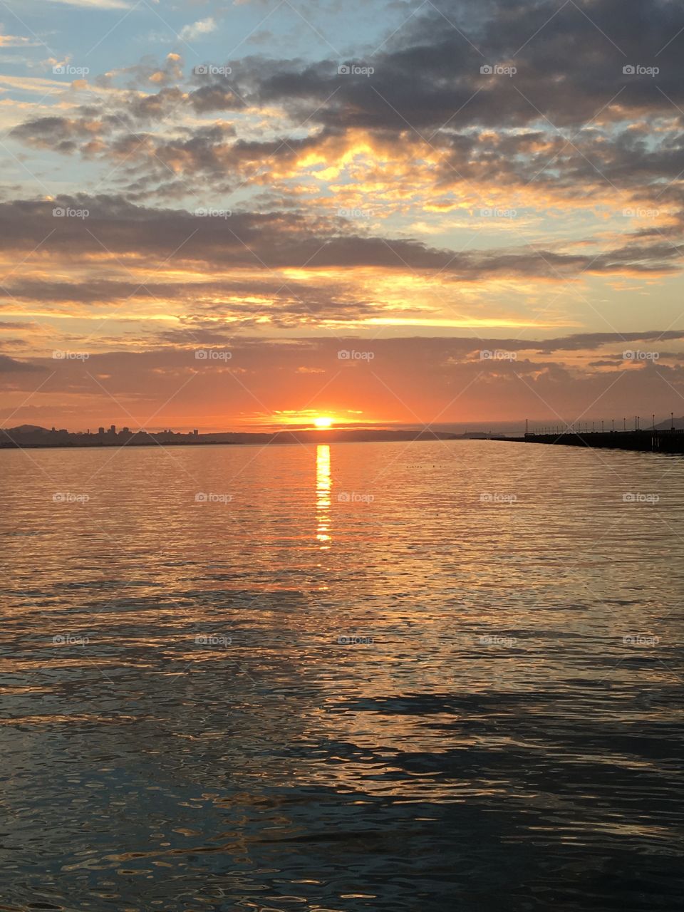 A drop of gold dissolving into the sea and the sky. Beautiful sunset by the ocean 