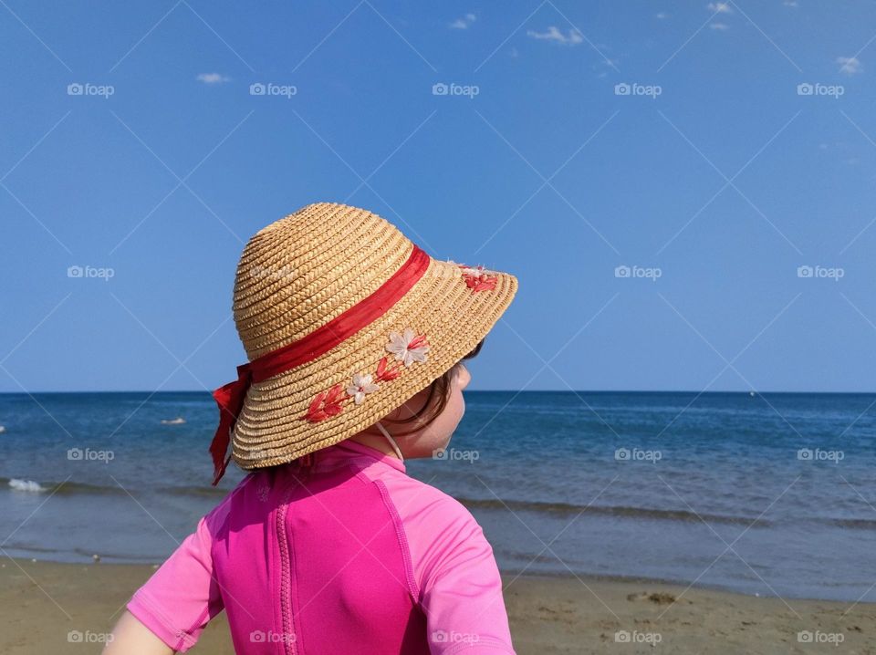 Summertime - Beautiful young girl looking at the sea