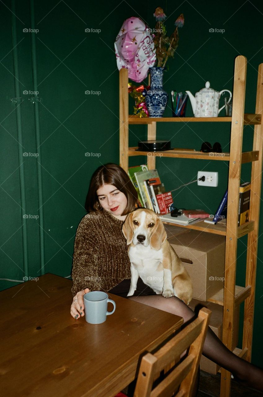 cachorro sentado na sala com a sua dona