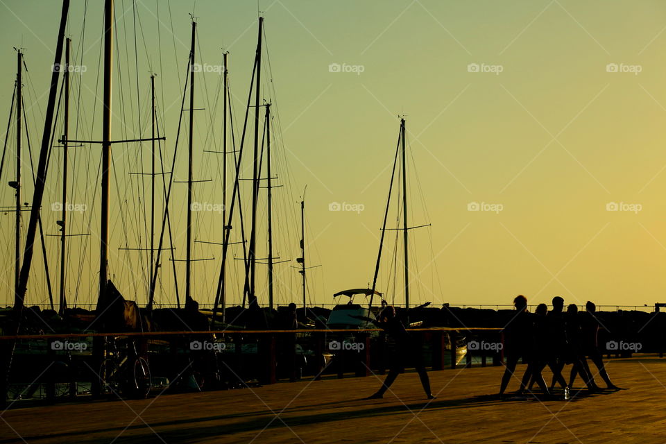 stretching near sailing boats. gymnastic in tel aviv pier at golden hour