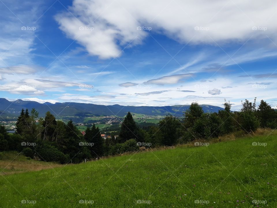 green field mountains and a blue sky with white clouds