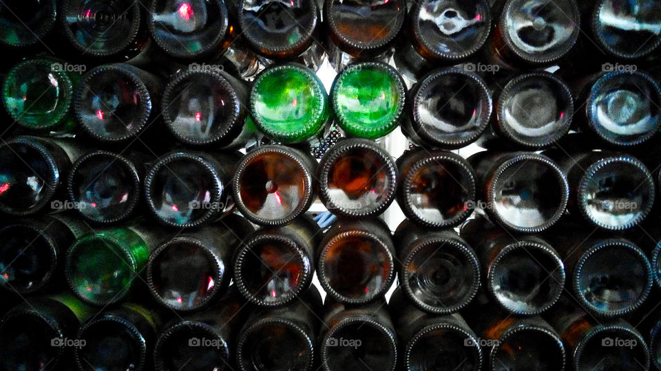 Wall made of empty brown and green beer bottles.