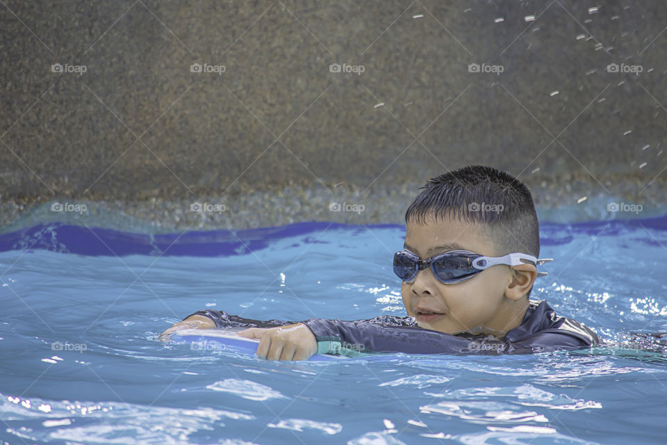 Asean boys are swimming in the pool.