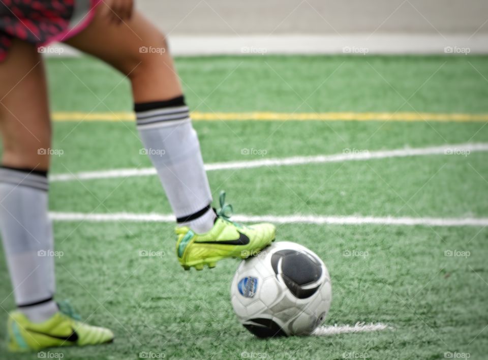 Foot On A Soccer Ball. Girl Preparing To Kick A Soccer Ball
