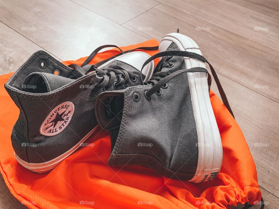 Converse on an orange travel bag 