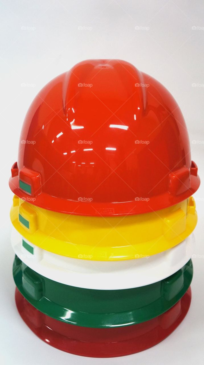 Photo of various colors of safety helmets on a white background