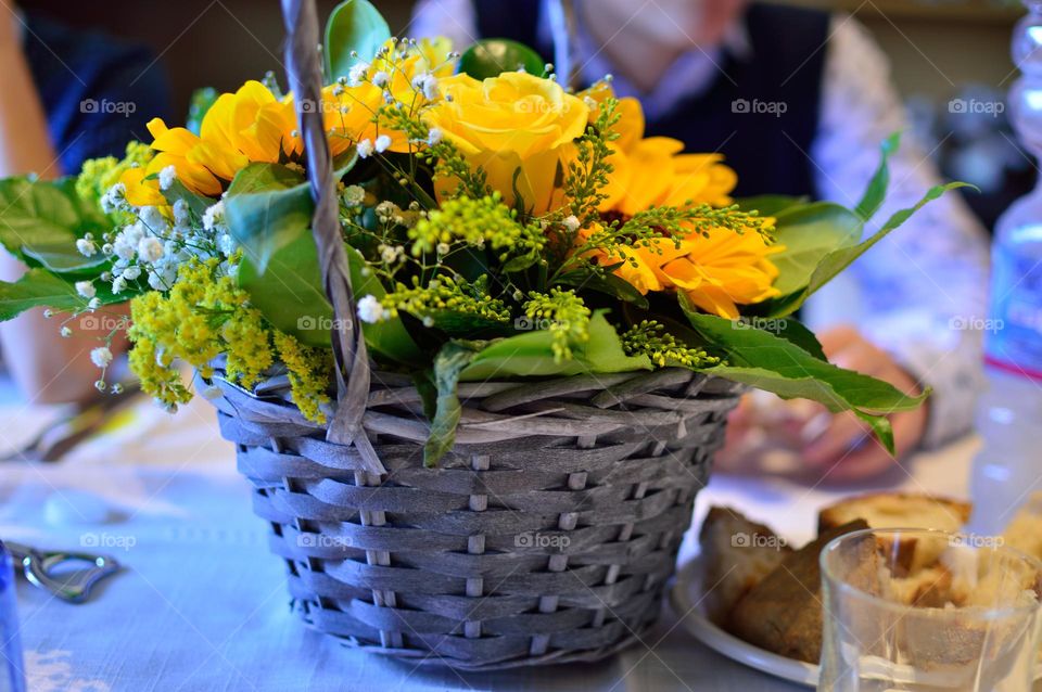 yellow flowers in straw basket as vase