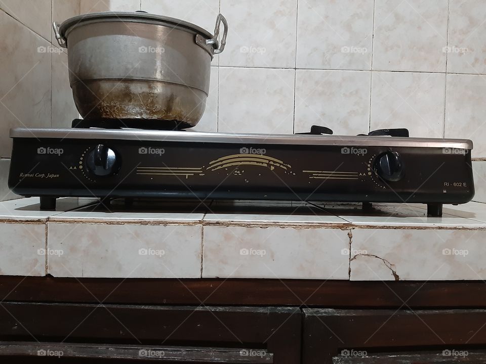 A stove and a big metal pan in the kitchen