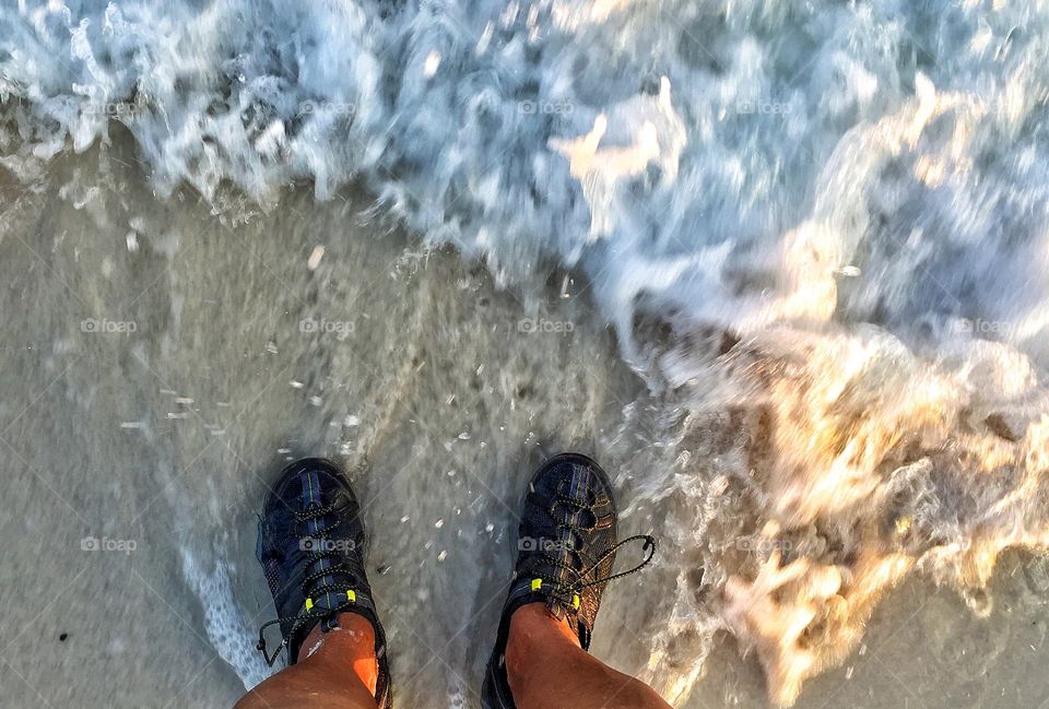 Point view of feet in the surf