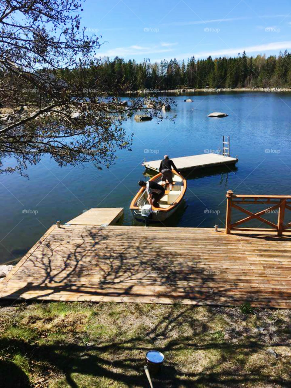 Two men standing on boat over the lake