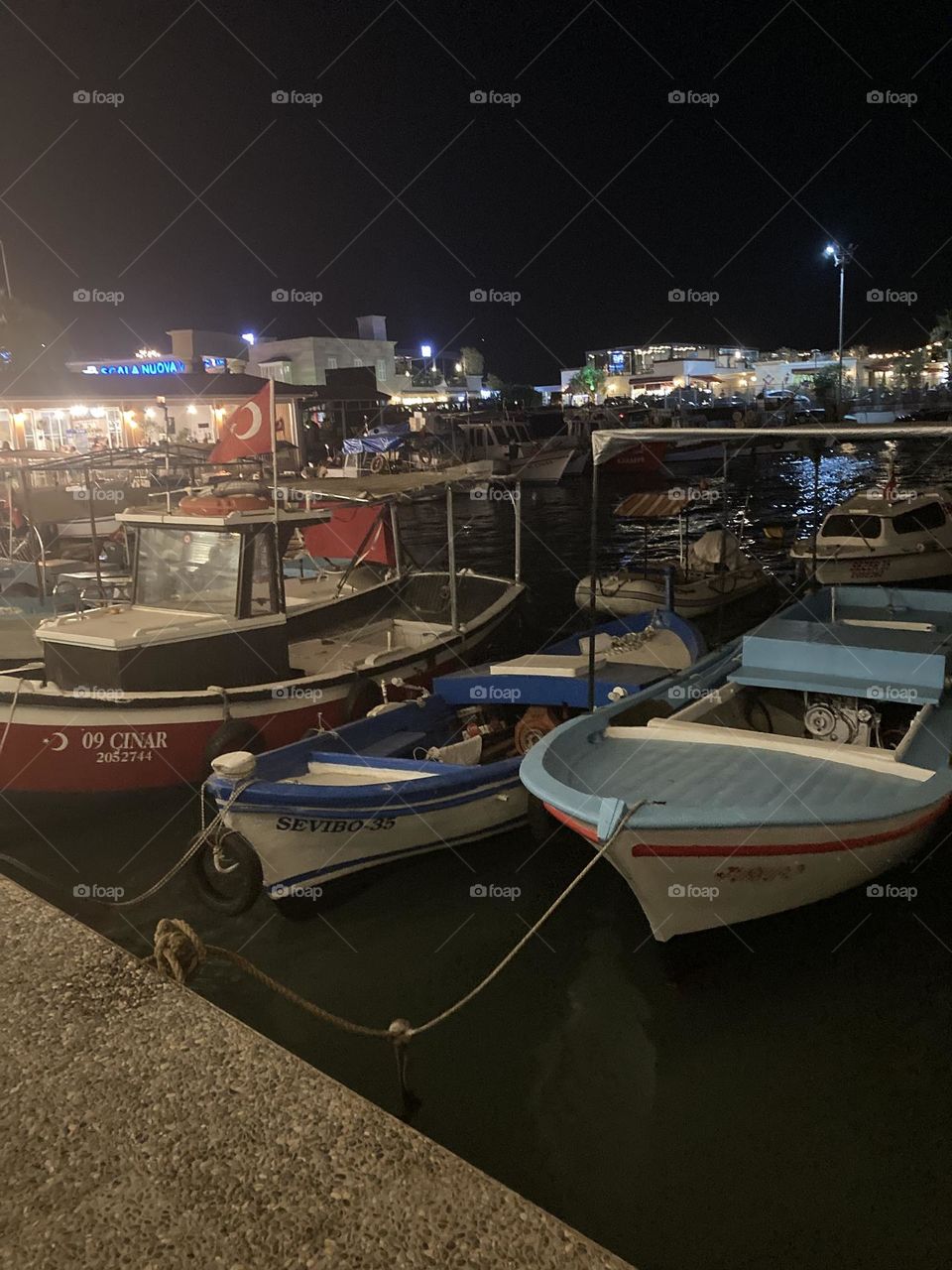 Night in Turkey by the ocean. Boats. Empty streets in the sunny kusadasi Turkey. Palms and empty roads. Summertime photo. Holidays adventure.