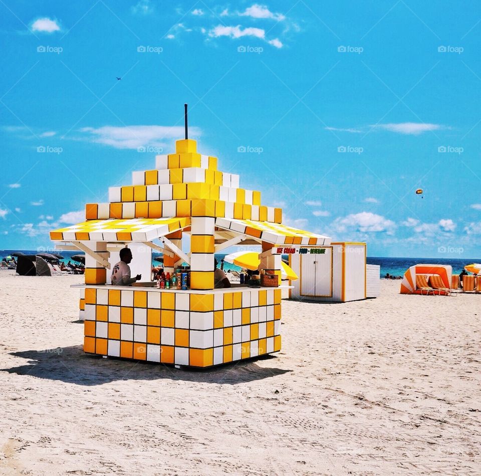 The colors of summer . Yellow and white snack hut on Miami Beach