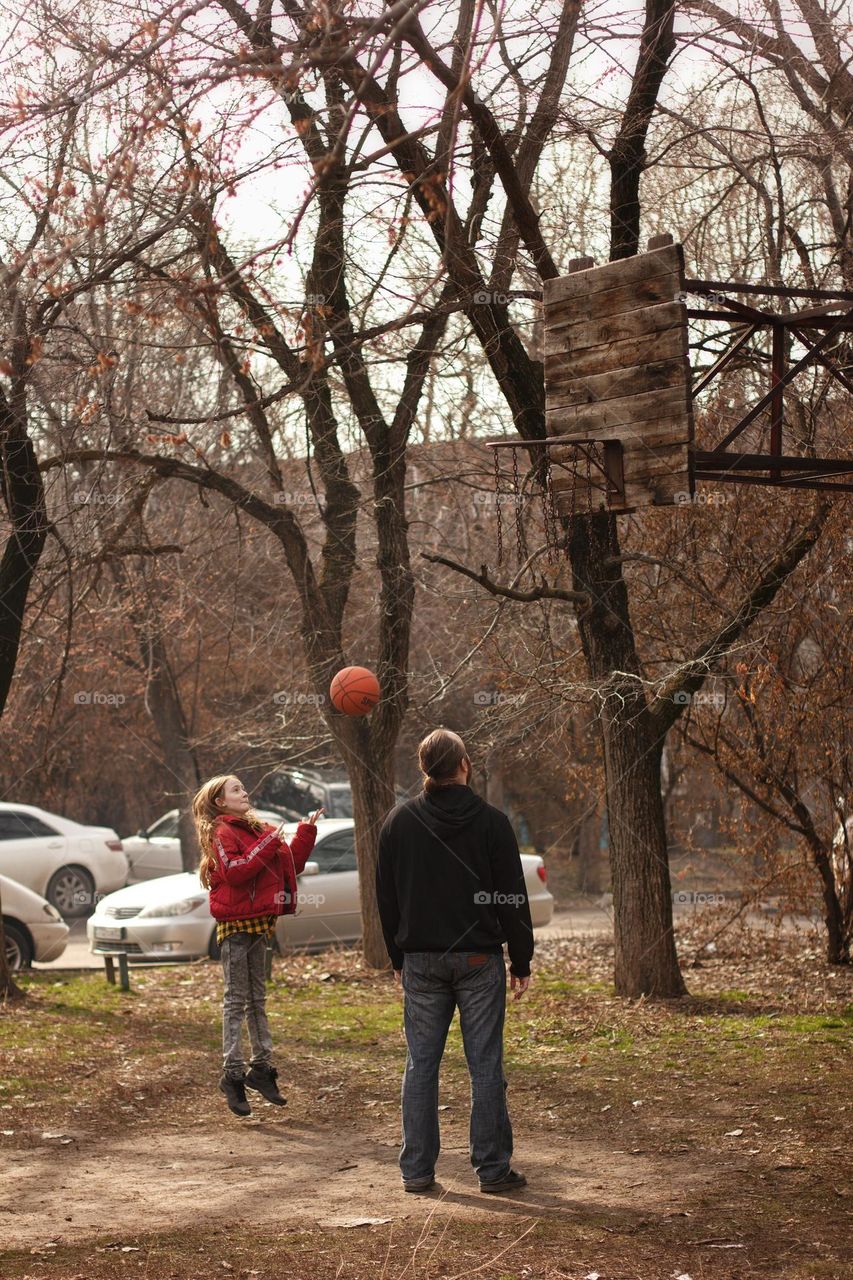 Father and daughter playing basketball in the yard