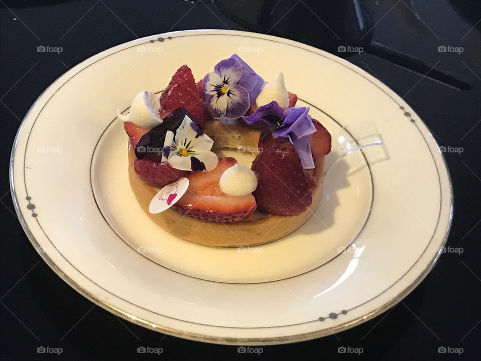 A tart with strawberries and violets