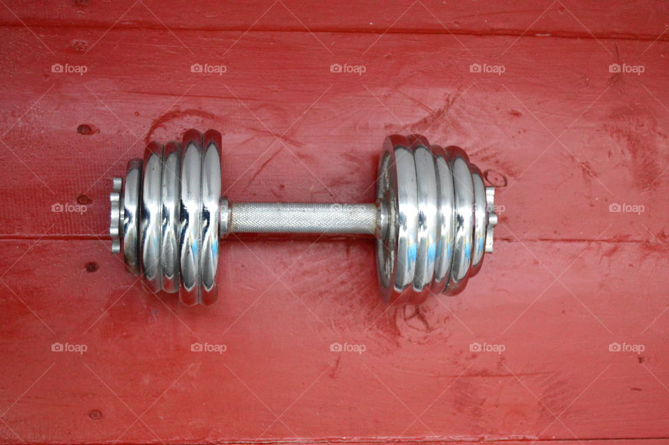 Red wooden floor with dumbbells on him