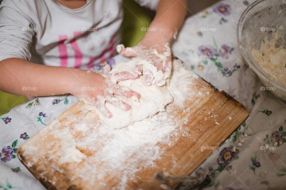 Child while playing with pasta and flour during the quarantine from Covid-19