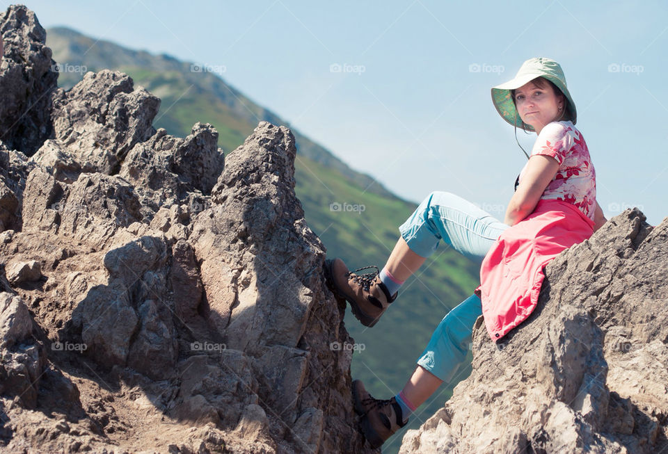 Woman resting on rock in mountains