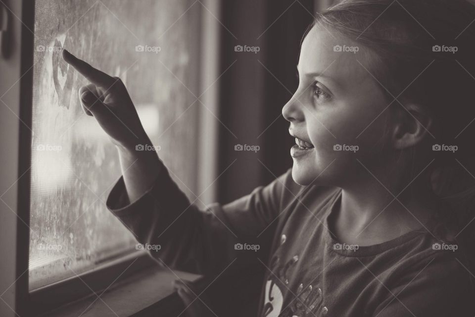 Drawing hearts in the window.