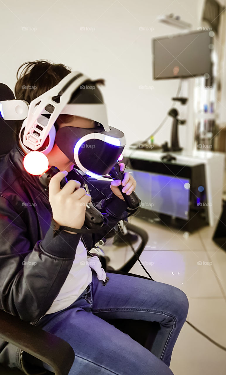 Modern technology concept - child with vr glasses play a virtual game.