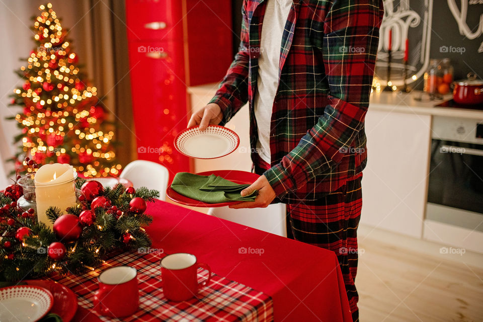 man sets a beautiful decorated winter table for a festive dinner.  Merry Christmas and Happy New Year.