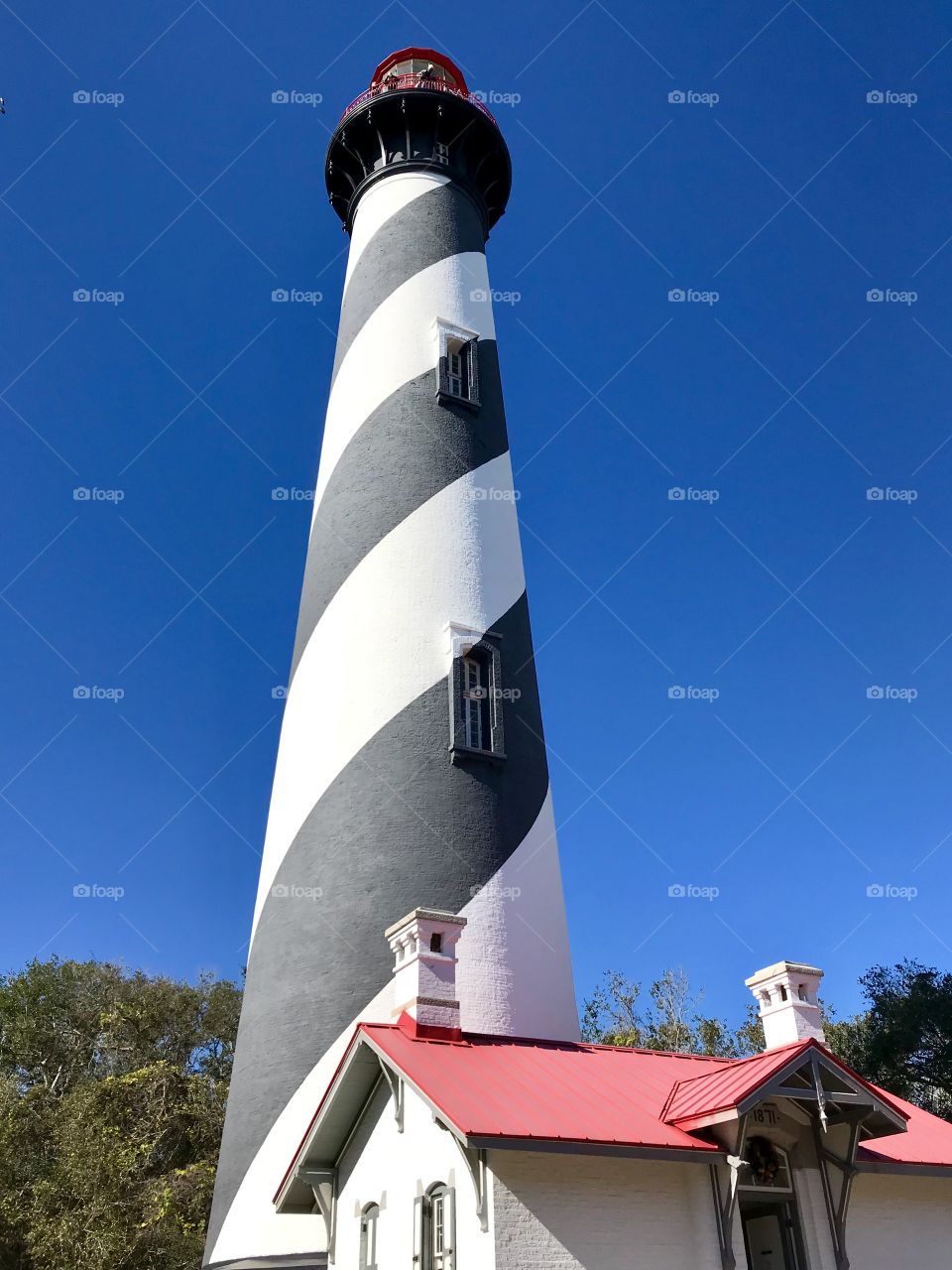 Black and white striped lighthouse against a clear blue sky 
