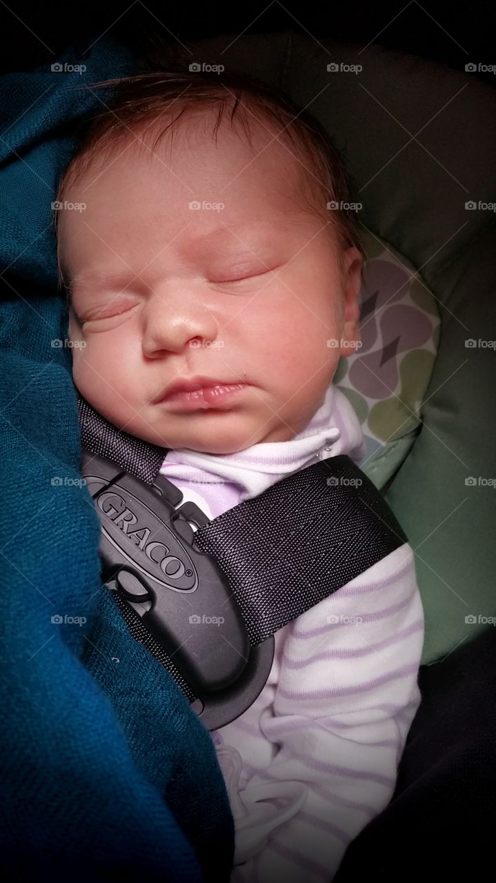 Newborn in car seat.