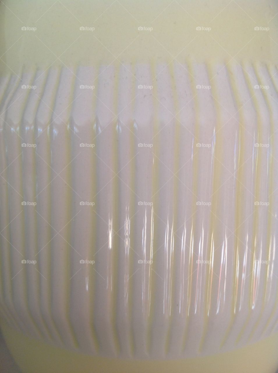 Lines on a yellow and white glass vase.