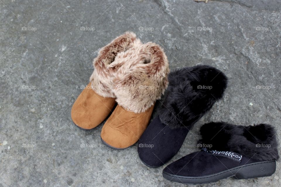 Tan and Black Faux Fur Slippers on rock