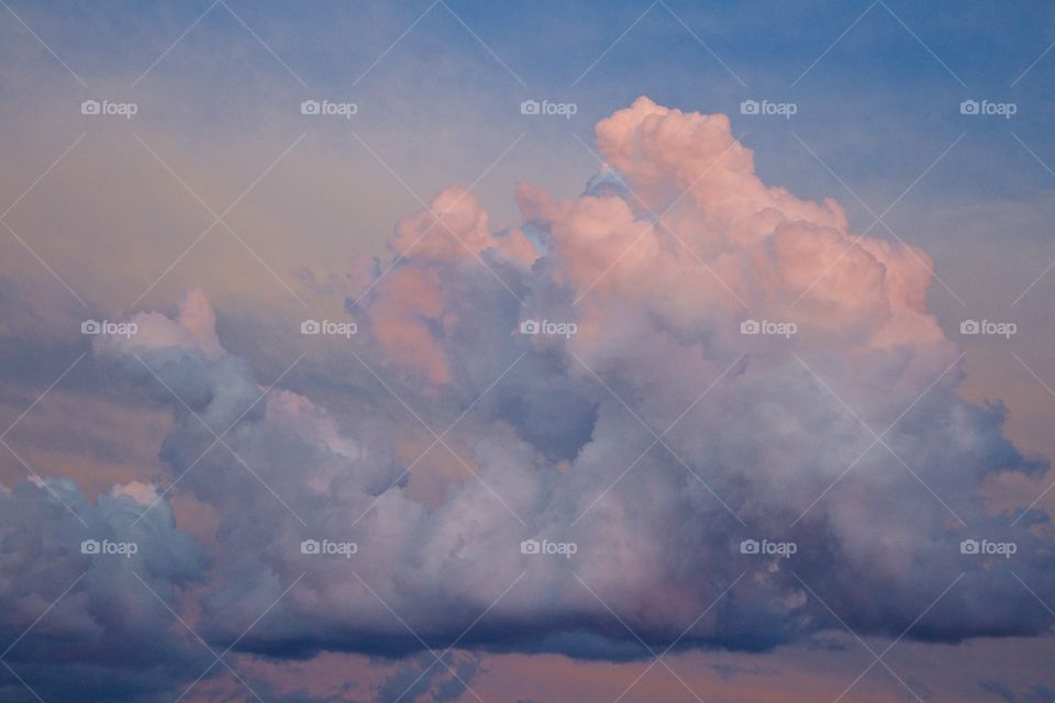 Pastel-colored clouds towering in the sky at sunset