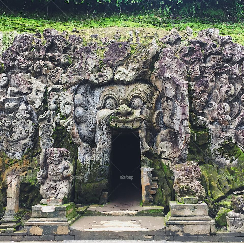 The cave entrance at Bali’s Elephant Cave Temple, adorned with carvings of mythical creatures.