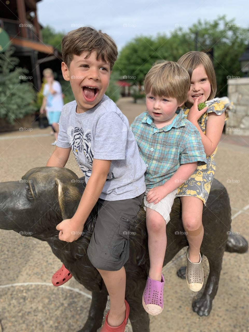Kids playing on a dog statue 