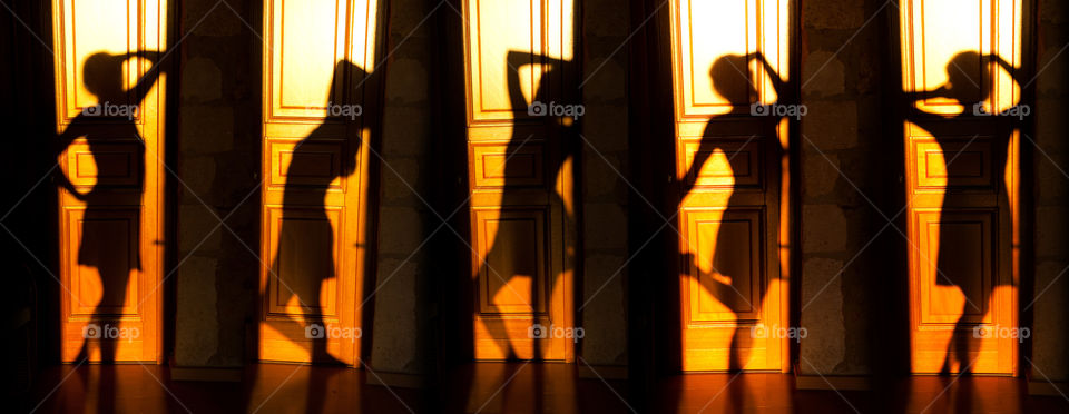 Shadow silhouette of girl in different poses on the doors